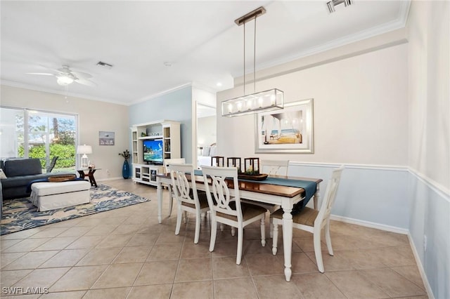 dining area featuring crown molding, ceiling fan with notable chandelier, and light tile patterned floors