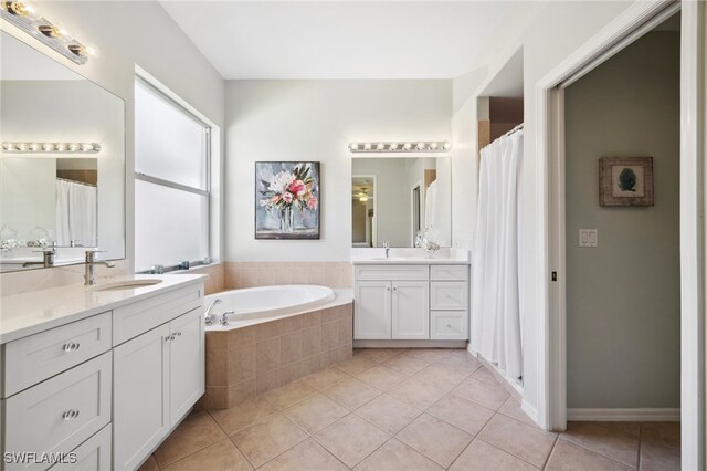 bathroom with vanity, tile patterned floors, and tiled bath