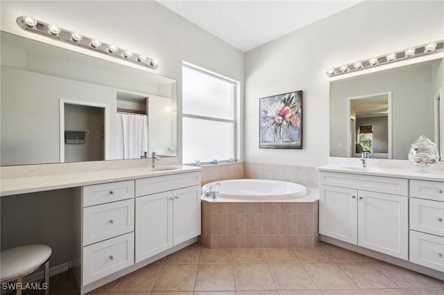 bathroom featuring vanity, tile patterned floors, and tiled bath