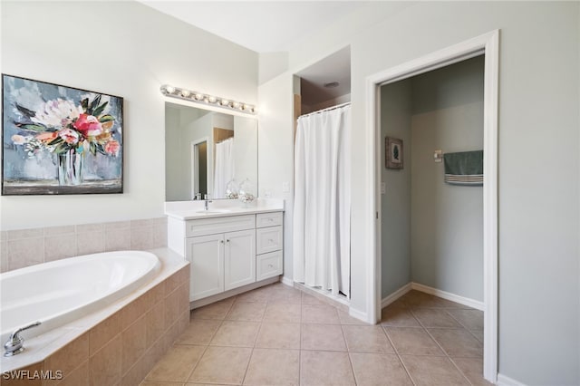 bathroom featuring tile patterned flooring, vanity, and a relaxing tiled tub