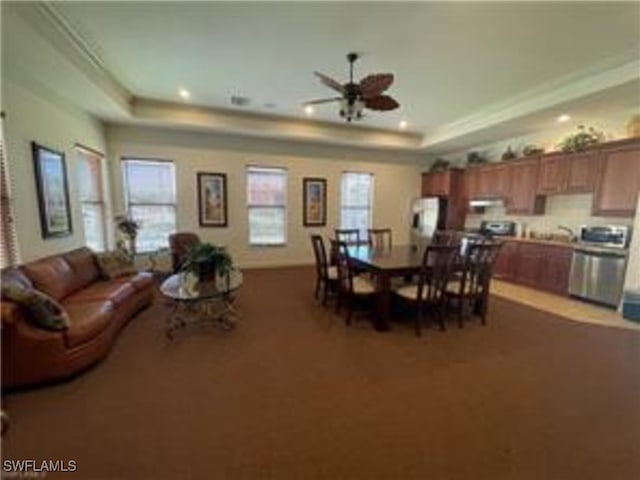 dining area featuring a raised ceiling, recessed lighting, and ceiling fan