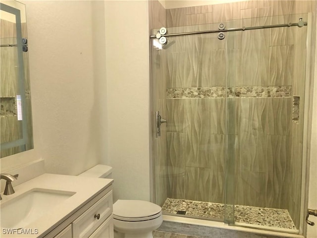 bathroom featuring vanity, a shower, and toilet