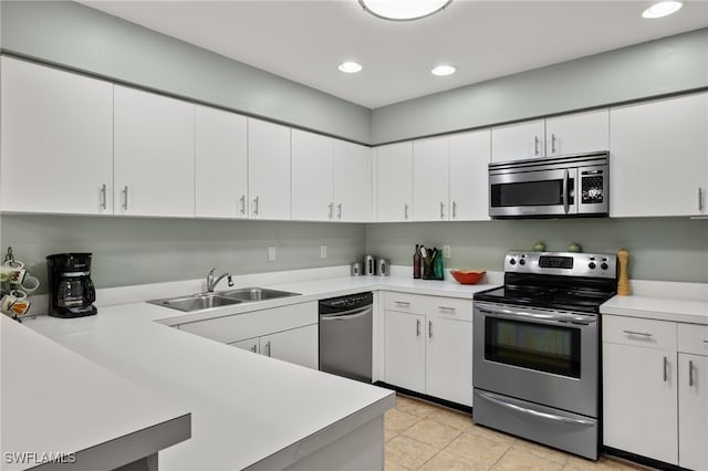 kitchen with sink, white cabinets, stainless steel appliances, and light tile patterned floors