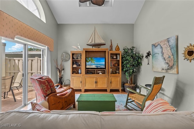 living room featuring ceiling fan and high vaulted ceiling