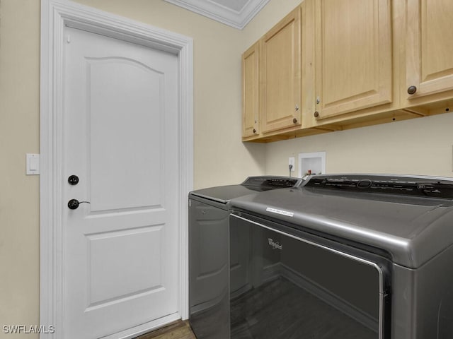 laundry area with washer and dryer, cabinets, and ornamental molding