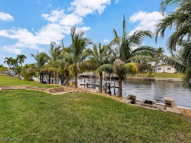 view of dock featuring a water view and a yard