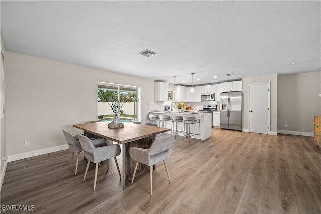 dining area featuring sink and hardwood / wood-style floors