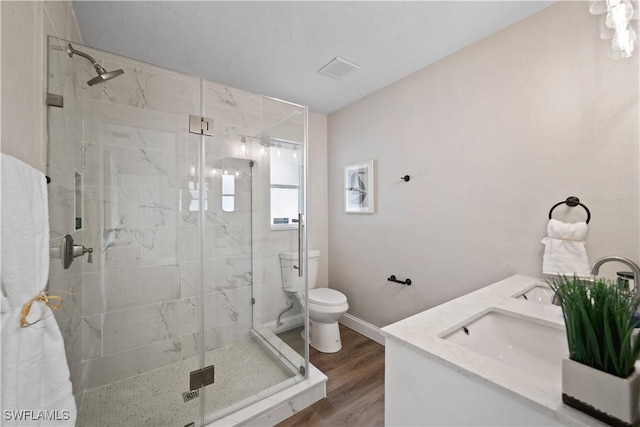 bathroom featuring hardwood / wood-style flooring, toilet, vanity, and an enclosed shower