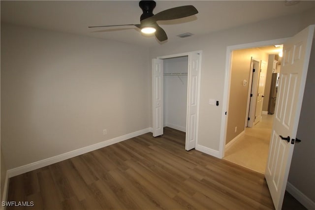 unfurnished bedroom with hardwood / wood-style flooring, ceiling fan, and a closet