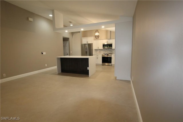 kitchen with lofted ceiling, backsplash, appliances with stainless steel finishes, a kitchen island, and white cabinetry