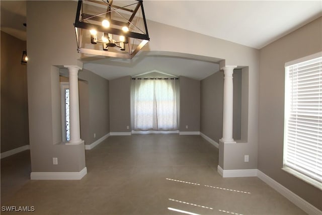 empty room featuring decorative columns, vaulted ceiling, and a notable chandelier