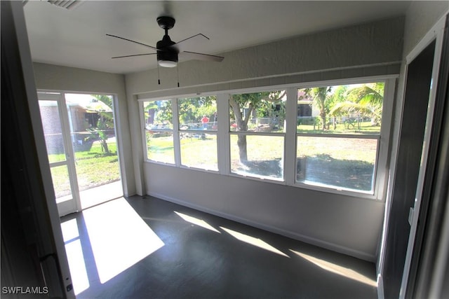 unfurnished sunroom with ceiling fan and a wealth of natural light