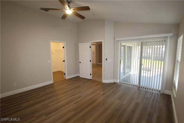 unfurnished bedroom with access to exterior, a spacious closet, dark hardwood / wood-style flooring, lofted ceiling, and a closet