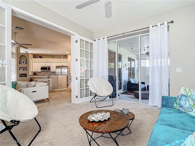 living room with ceiling fan and light carpet