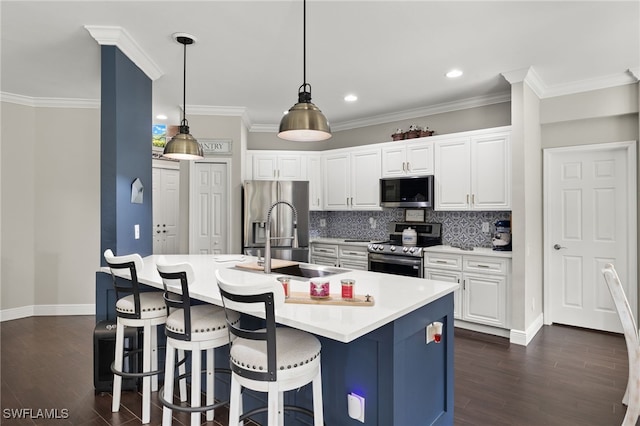 kitchen with pendant lighting, white cabinets, sink, an island with sink, and stainless steel appliances