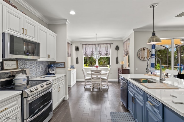 kitchen featuring blue cabinetry, white cabinets, decorative light fixtures, and appliances with stainless steel finishes