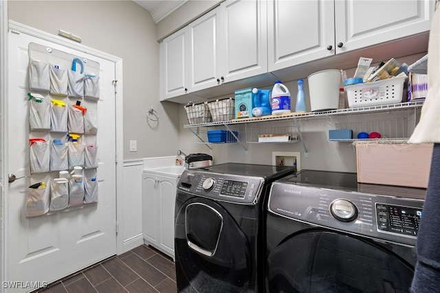 clothes washing area featuring separate washer and dryer, sink, and cabinets