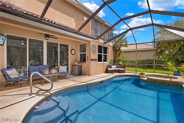 view of pool with an outdoor living space, glass enclosure, ceiling fan, an in ground hot tub, and a patio area