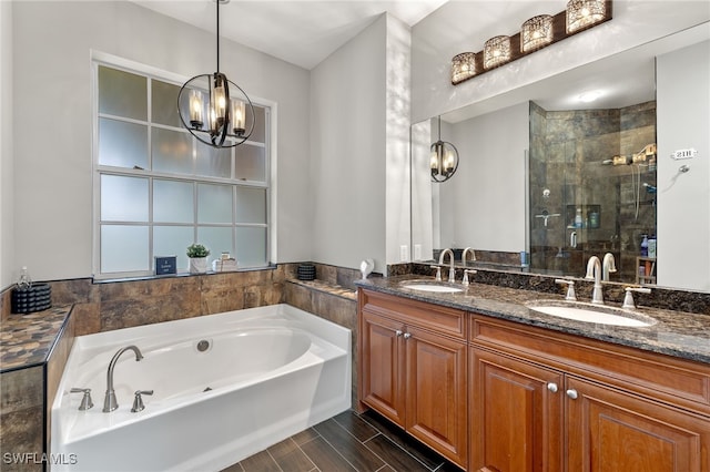 bathroom with a notable chandelier, vanity, and independent shower and bath