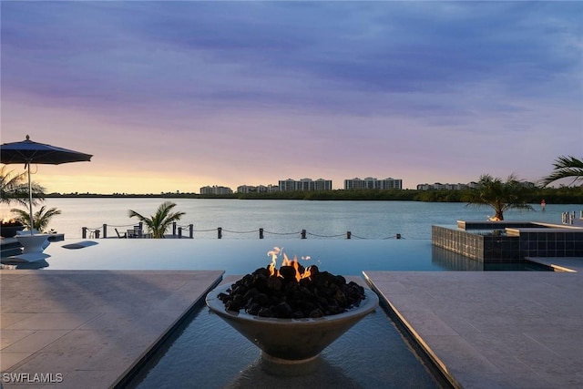 exterior space featuring a fire pit and a water view