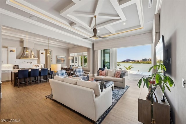 living room featuring coffered ceiling, ceiling fan, crown molding, and light wood-type flooring