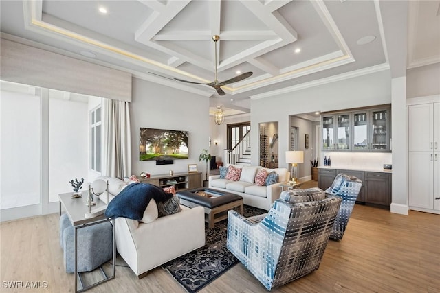 living room featuring ornamental molding, light hardwood / wood-style flooring, and coffered ceiling