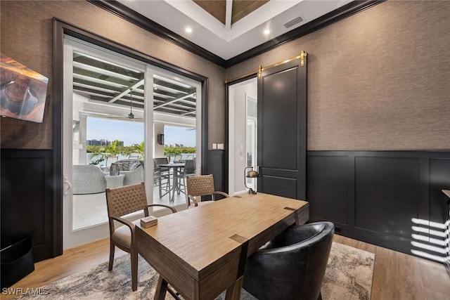 dining room featuring crown molding and light hardwood / wood-style flooring