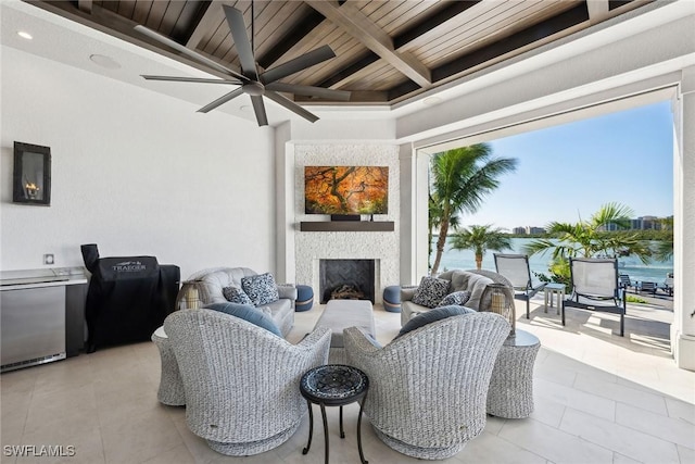 living room with a large fireplace, ceiling fan, wood ceiling, and plenty of natural light