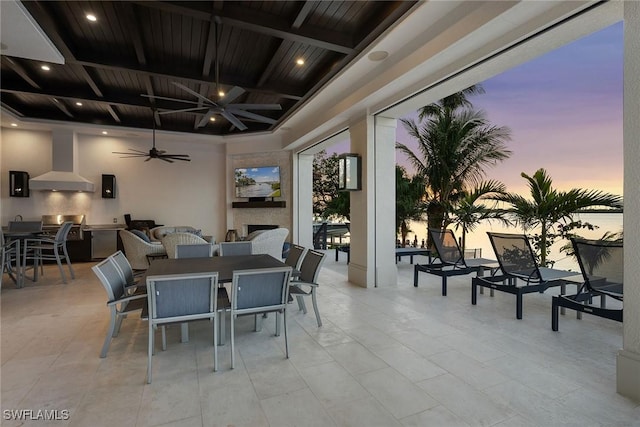 dining space with ceiling fan, wooden ceiling, and a fireplace