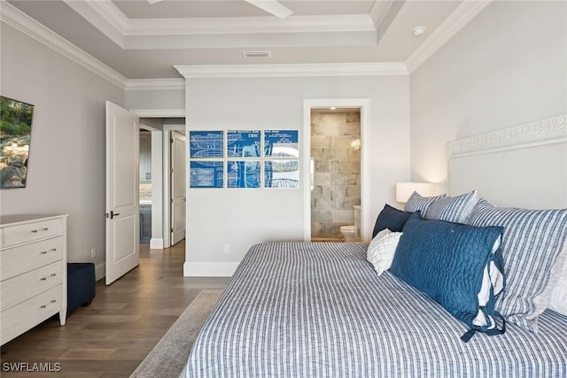 bedroom featuring crown molding, a raised ceiling, dark hardwood / wood-style floors, and connected bathroom