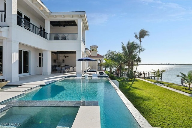 view of pool featuring a patio area, a yard, and a water view