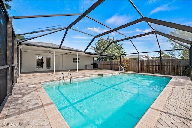 view of pool with ceiling fan, central AC unit, glass enclosure, and a patio