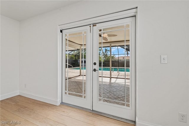 doorway to outside with ceiling fan and light wood-type flooring