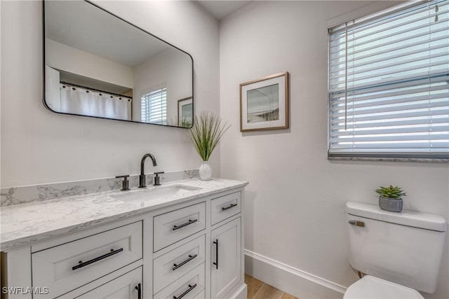 bathroom featuring vanity, hardwood / wood-style floors, and toilet