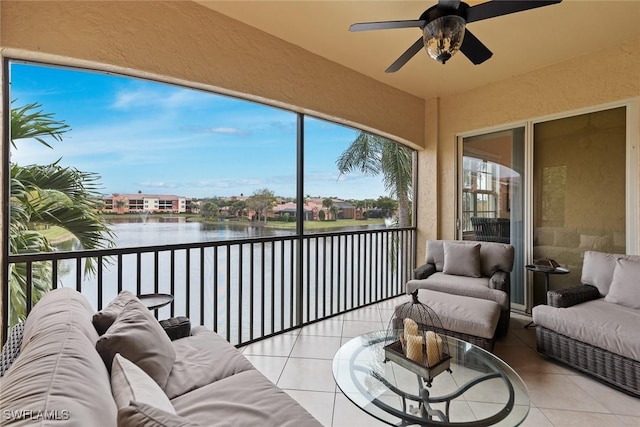 sunroom featuring ceiling fan, a wealth of natural light, and a water view