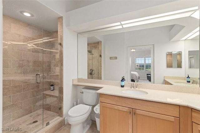 bathroom with walk in shower, vanity, and toilet