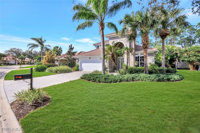 mediterranean / spanish-style home with a front lawn and a garage