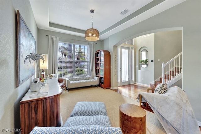 interior space with light hardwood / wood-style floors and a raised ceiling