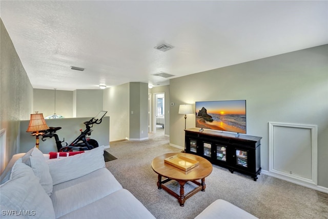 living room featuring light colored carpet and a textured ceiling