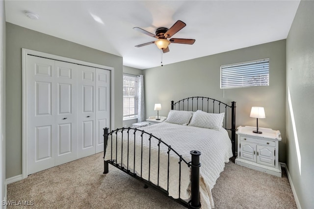 carpeted bedroom with ceiling fan and a closet