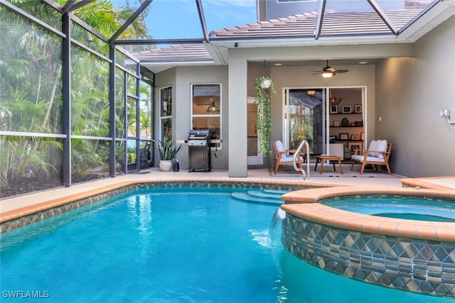 view of pool featuring an in ground hot tub, area for grilling, ceiling fan, glass enclosure, and a patio area