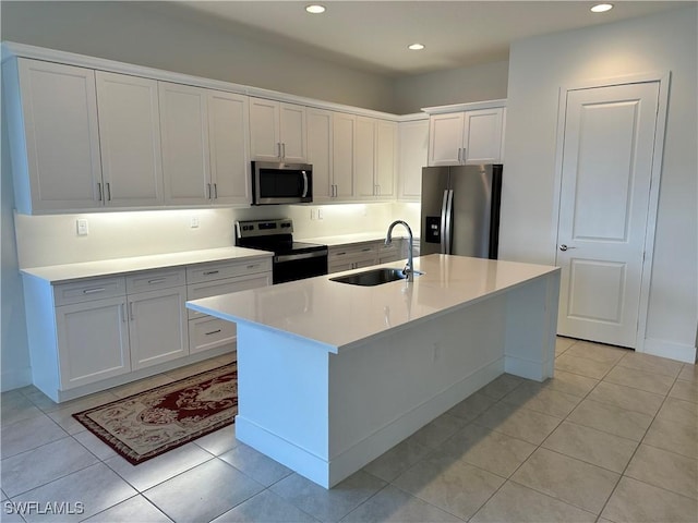 kitchen with white cabinets, light tile patterned flooring, sink, and stainless steel appliances