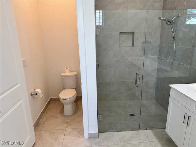 bathroom with an enclosed shower, vanity, toilet, and tile patterned flooring