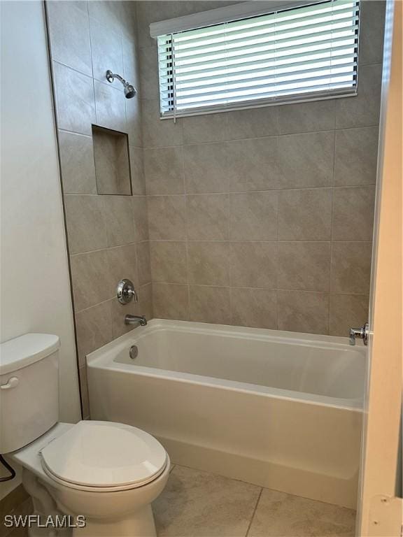 bathroom featuring tile patterned floors, tiled shower / bath combo, and toilet