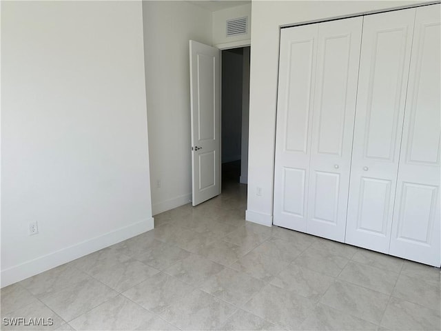 unfurnished bedroom with a closet and light tile patterned flooring