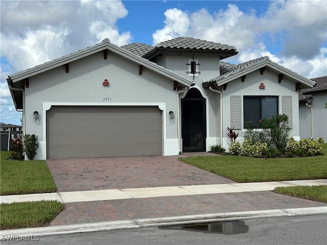 mediterranean / spanish-style house featuring a front yard and a garage