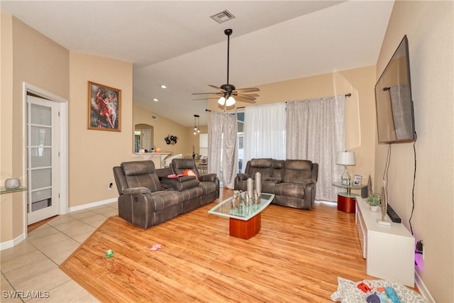 living room featuring ceiling fan, light tile patterned flooring, and vaulted ceiling