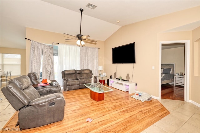 living room with ceiling fan, vaulted ceiling, and light tile patterned flooring