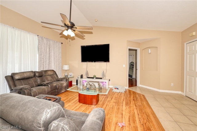 tiled living room with ceiling fan and vaulted ceiling