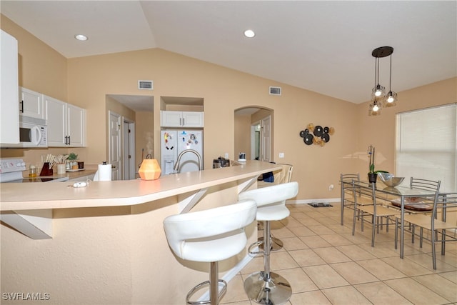 kitchen with decorative light fixtures, white cabinets, white appliances, and lofted ceiling